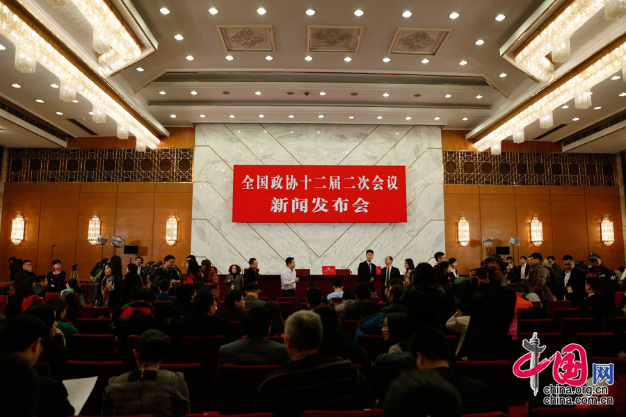 2014兩會首場發(fā)布會記者表情:“拍照神器”