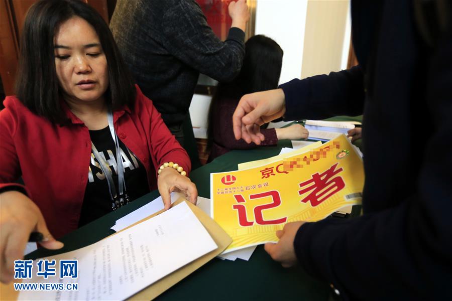 參加全國政協(xié)十二屆五次會議采訪報道的記者領(lǐng)取證件