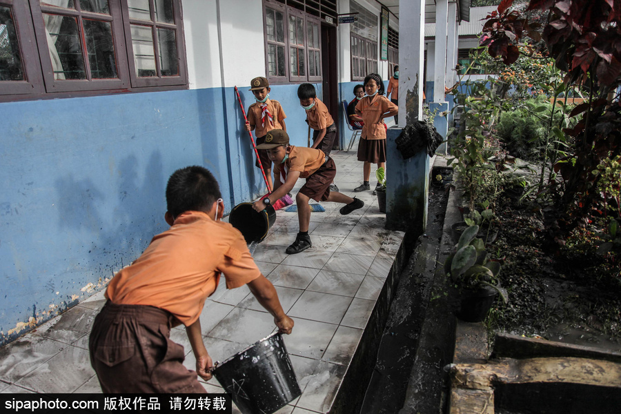 錫納朋火山噴發后 火山灰漫山遍野村民戴口罩清掃
