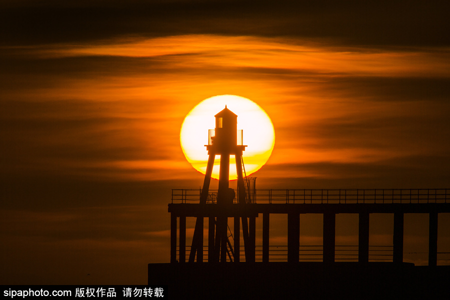 英國惠特比碼頭日出風光 燈塔影影綽綽景色美