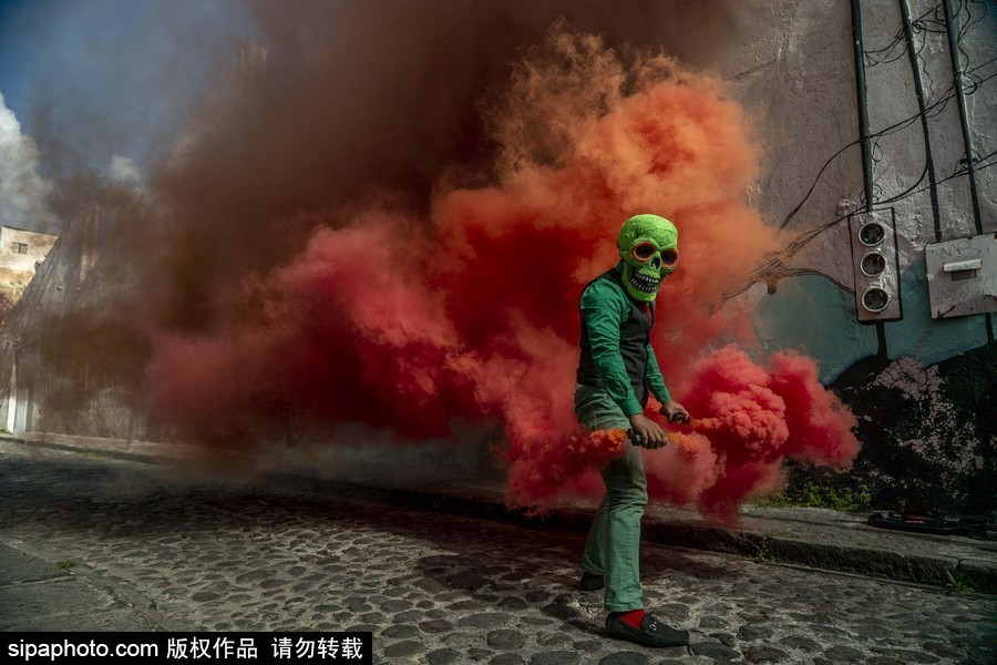 展現色彩魅力！墨西哥街頭“彩色骷髏”花6小時用彩煙“填滿”街道